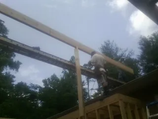 Carpenter setting a ridge beam over a new addition frame — Ice Dam Removal by Roofing Brothers in Avoca
